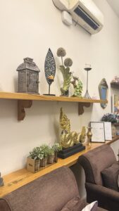 Wooden display shelf with golden Thai ornaments, lantern and plants in the waiting area of Arokaya Wellness Spa Thai massage St Kilda