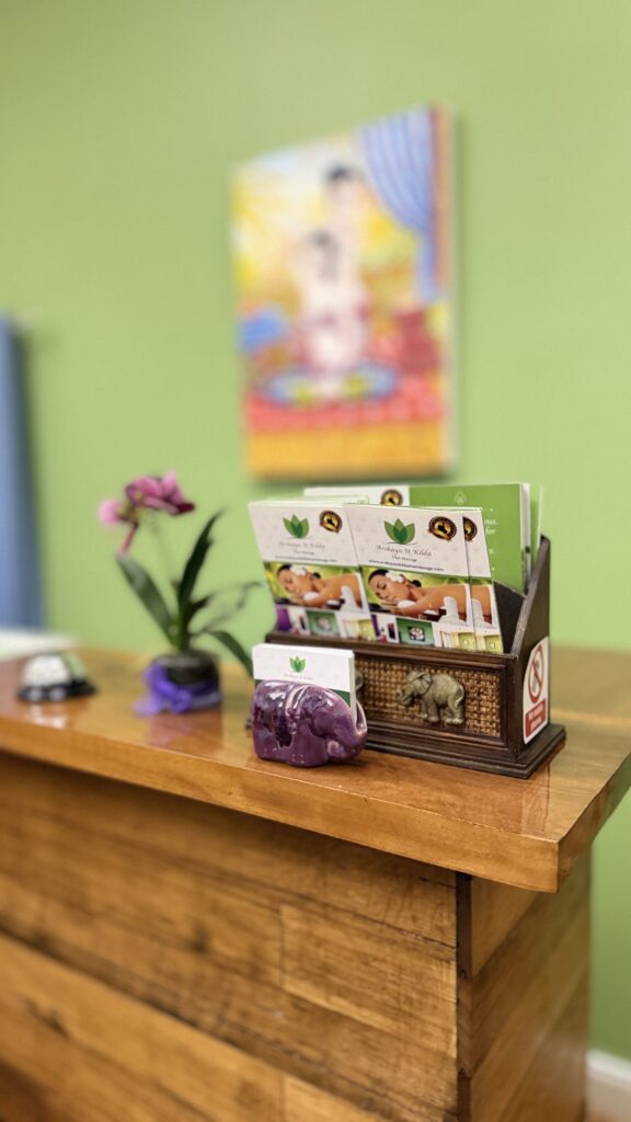 Reception counter with service menu brochures, orchid and Thai decor at Arokaya Wellness Spa Thai massage St Kilda