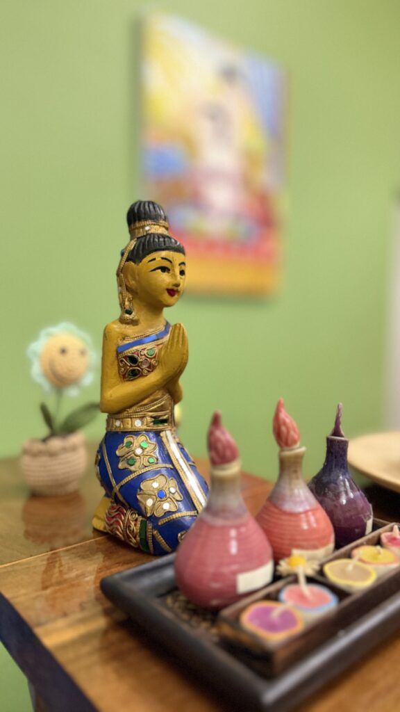 Traditional Thai praying figurine and colourful candles decor at Arokaya Wellness Spa Thai massage St Kilda