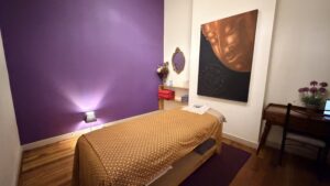 Single massage bed in a purple-toned treatment room with Buddha art at Arokaya Wellness Spa Thai massage St Kilda